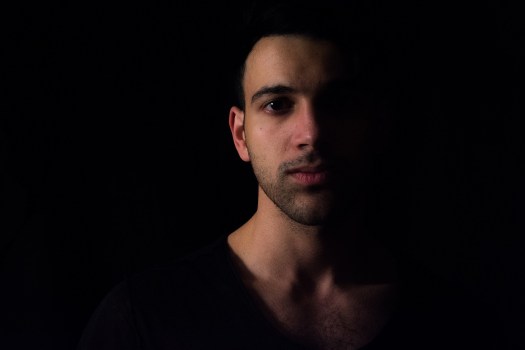 Dark haired man, face half in shadow, soulful eye