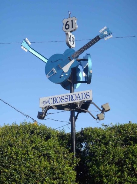 Crossroads with 3 blue guitar statues on a pole is a marker for Highways 61 and 49 in Mississippi