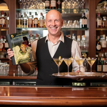 Curley the bartender holding A Peril in Unseen Frequencies