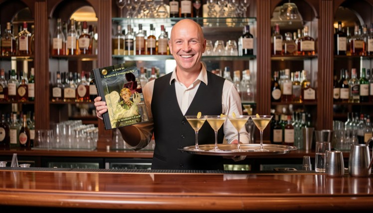Curley the bartender holding A Peril in Unseen Frequencies